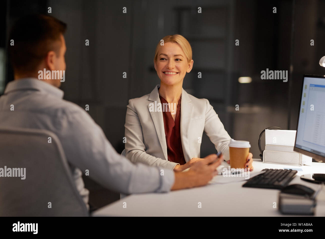business people drinking coffee at night office Stock Photo Alamy