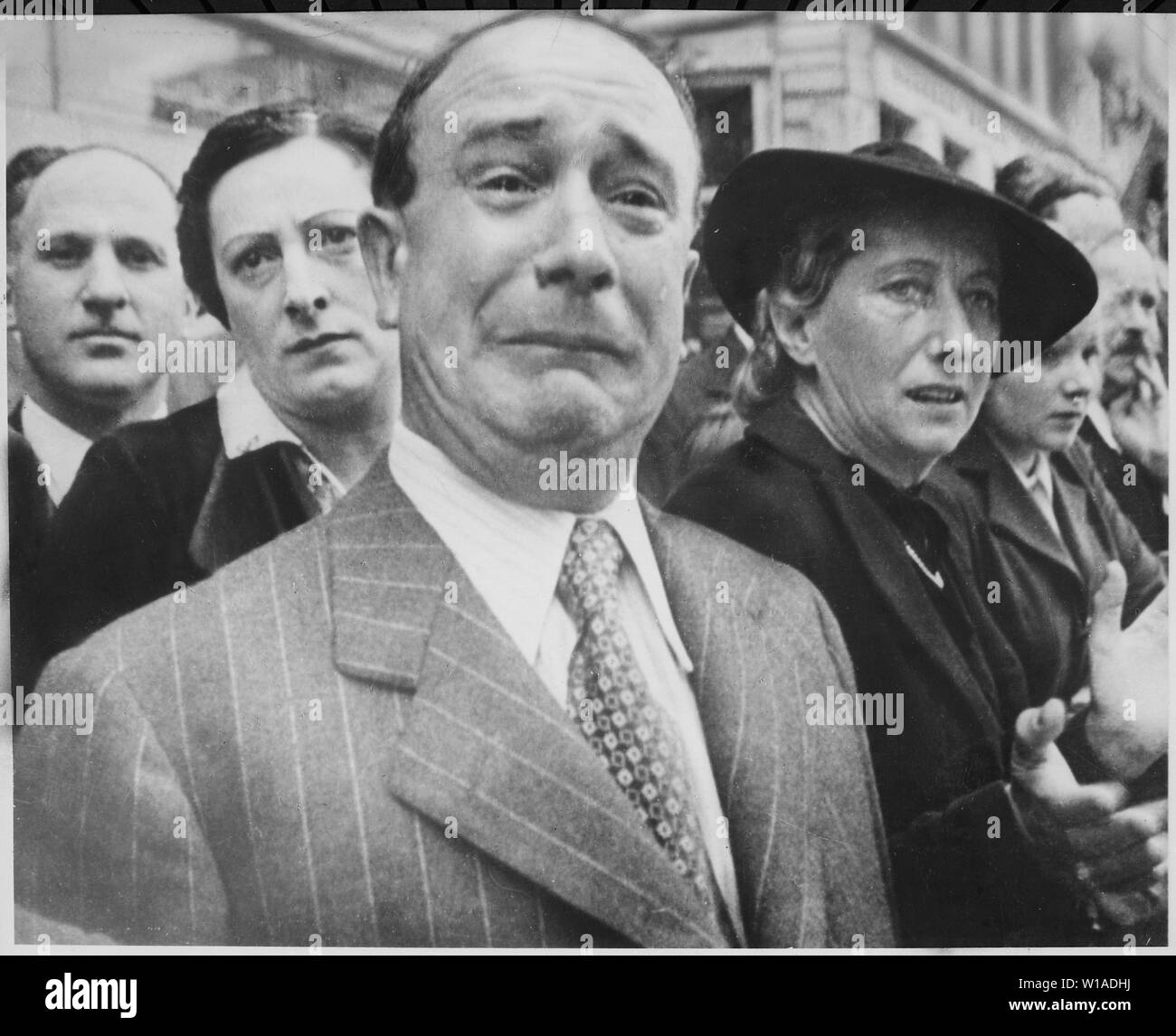 A Frenchman weeps as German soldiers march into the French capital, Paris, on June 14, 1940, after the Allied armies had been driven back across France.; A Frenchmen weeps as historic flags of French regiments are paraded down the streets of Marseille in February 1941, to be loaded on ships and sent to Algeria for safekeeping.  They had been removed from Paris prior to the Germans arriving, and had been given to forces under General Maxime Weygand.  After the war, the pictured man was identified as M. Jerôme Barzetti.[1] The image is taken from a film clip, a portion of which was later used in Stock Photo