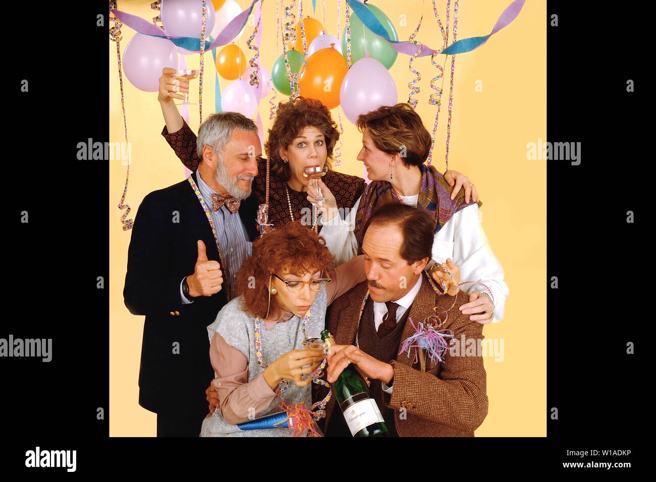 Five people celebrating at an office party a decorated room Stock Photo