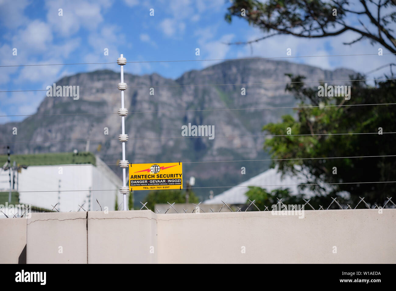 Electrical fence, with warning sign in Cape Town suburbs. Table
