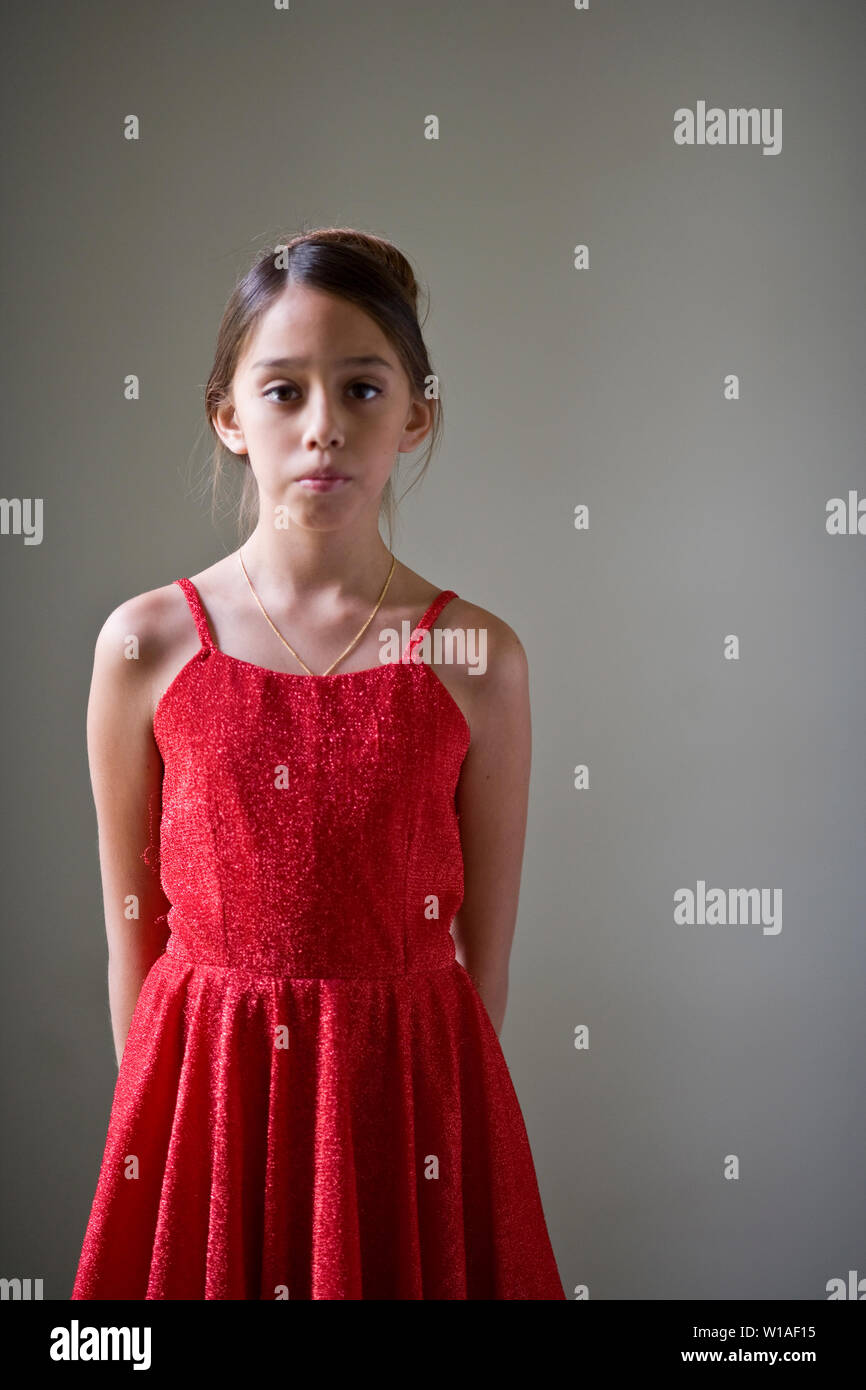 Portrait of a young girl wearing a red dress in a room Stock Photo - Alamy
