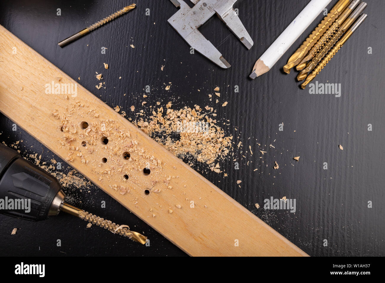 Drilling in a piece of dry planed wood. Holes made in the with