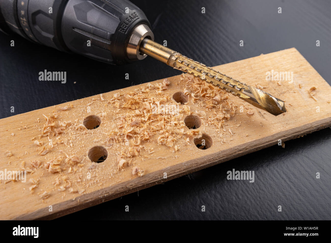 Drilling in a piece of dry planed wood. Holes made in the with