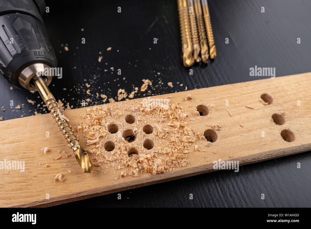 Drilling in a piece of dry planed wood. Holes made in the with