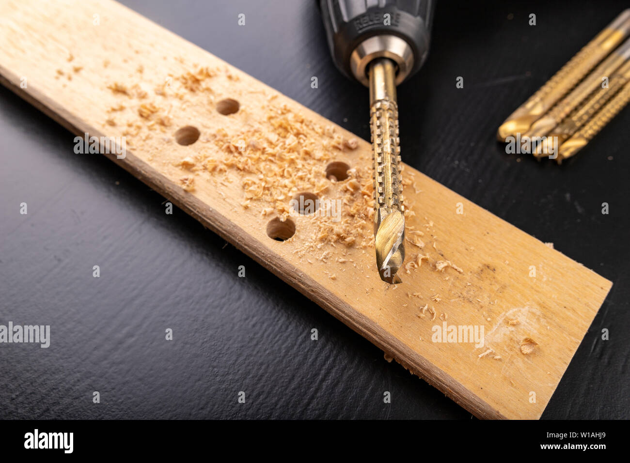 Drilling in a piece of dry planed wood. Holes made in the with