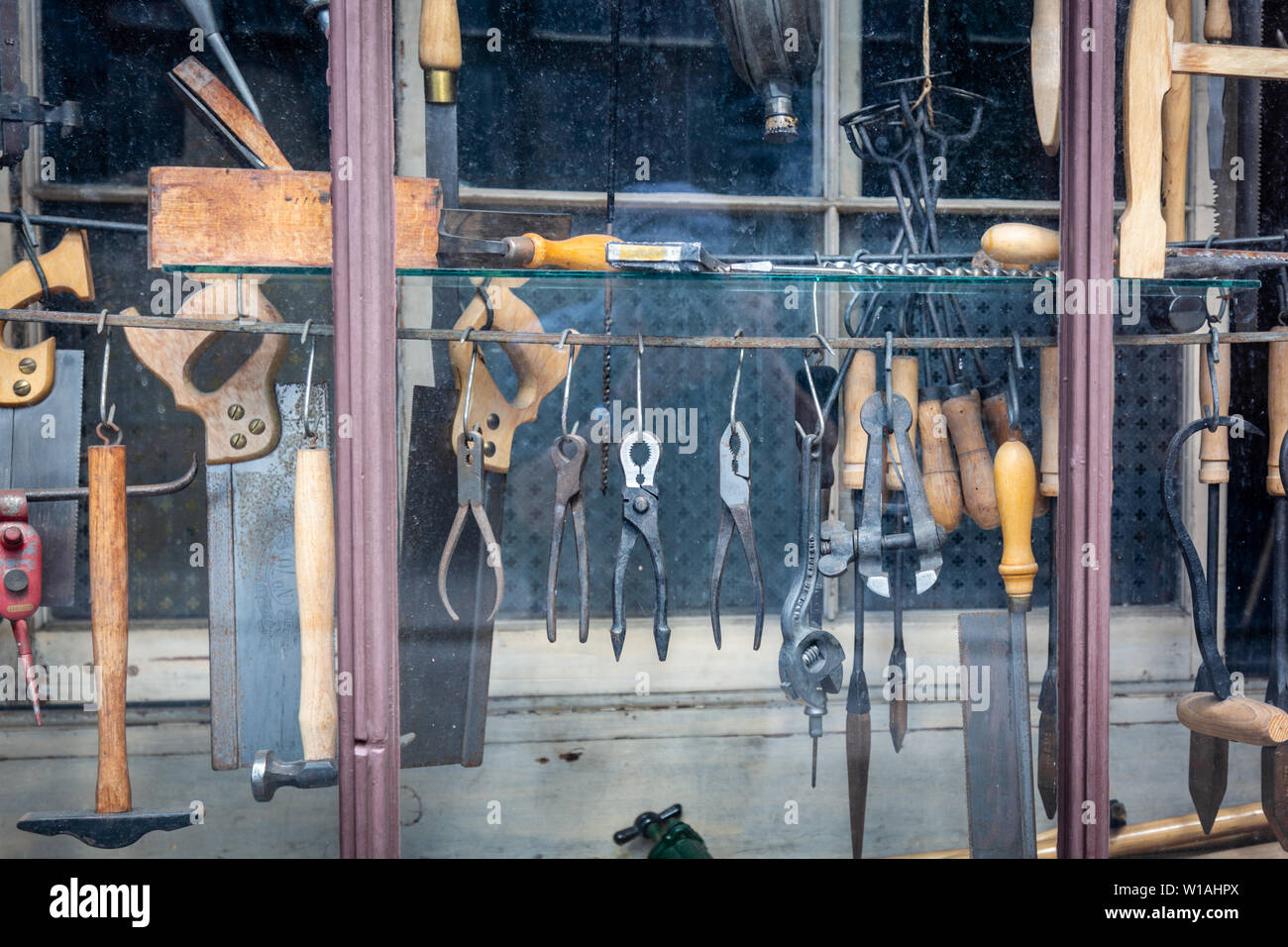 Traditional hardware shop window showing small tools for sale on display Stock Photo