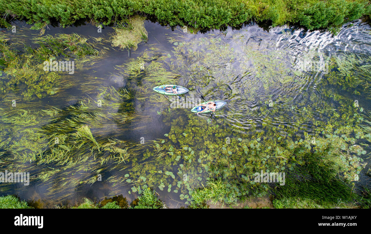 Aerial picture dated June 30th shows a  canoe  on the River Cam by Grantchester Meadows,Cambridgeshire, on Sunday afternoon as people make  the most of the good weather. Cooler weather is forecast for later in the week.  The Met Office forecast for today states rather cloudy across Scotland and Northern Ireland with some rain or heavy showers. Elsewhere, largely dry with sunny spells, although rather cloudy initially in the west. Feeling fresher for all, but still warm in any sunshine in the south.  Tonight:  Dry with clear spells overnight across the south and east. Rather cloudy elsewhere, w Stock Photo