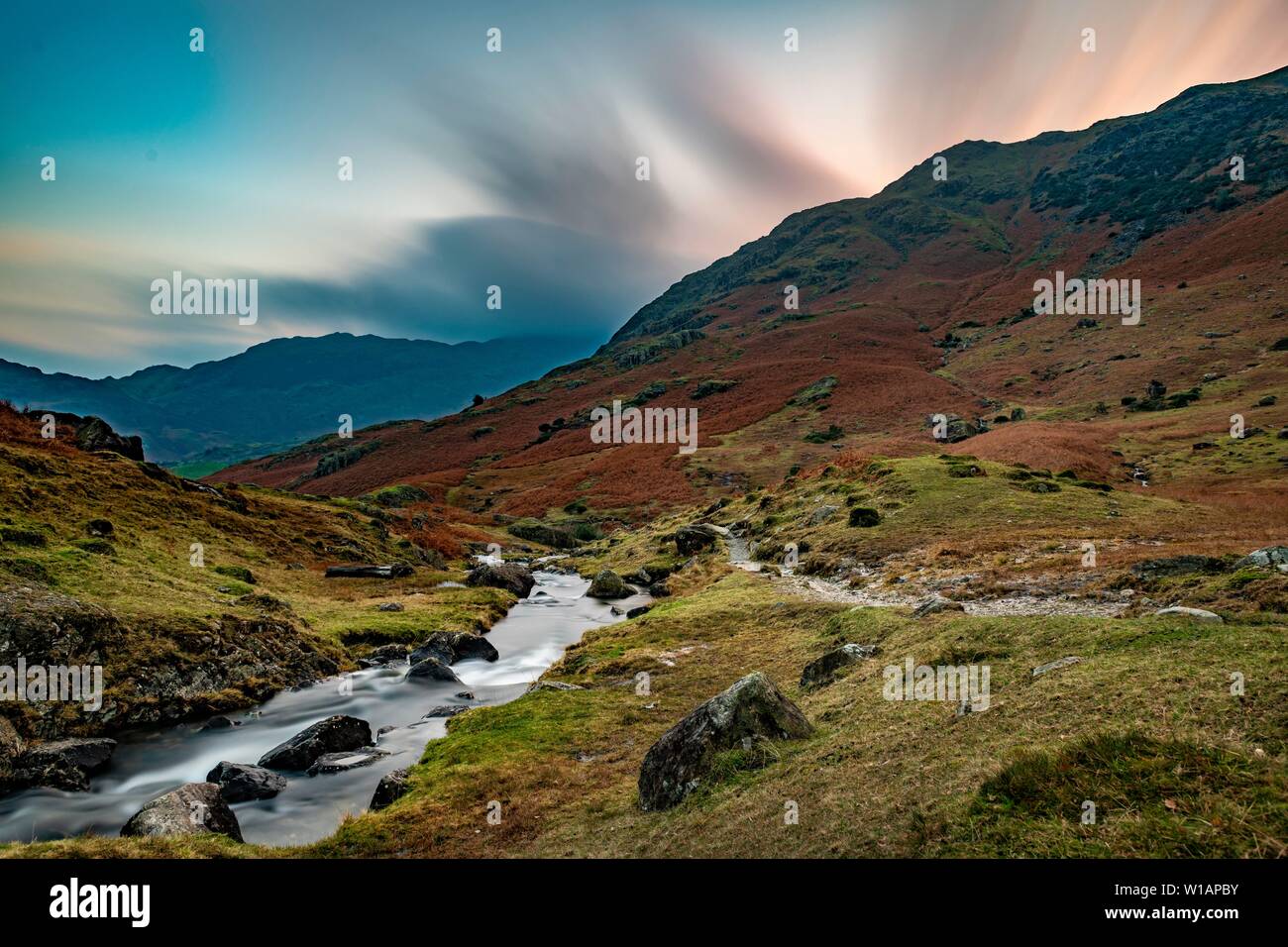 Brook run in autumnal hilly landscape with cloudy sky, Ambleside, Lake District National Park, Middle England, Great Britain Stock Photo