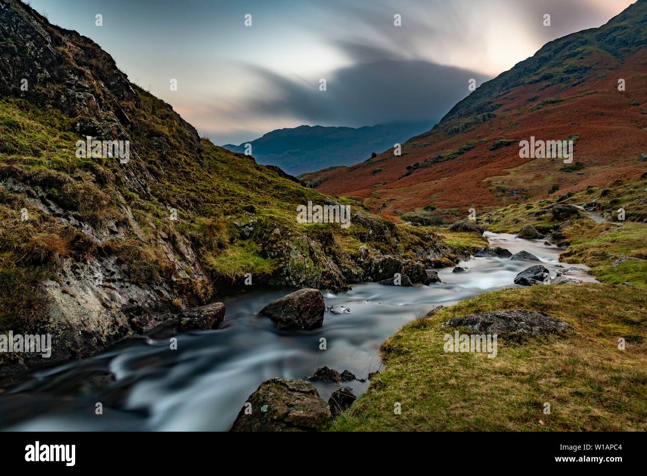 Brook run in autumnal hilly landscape with cloudy sky, Ambleside, Lake District National Park, Middle England, Great Britain Stock Photo