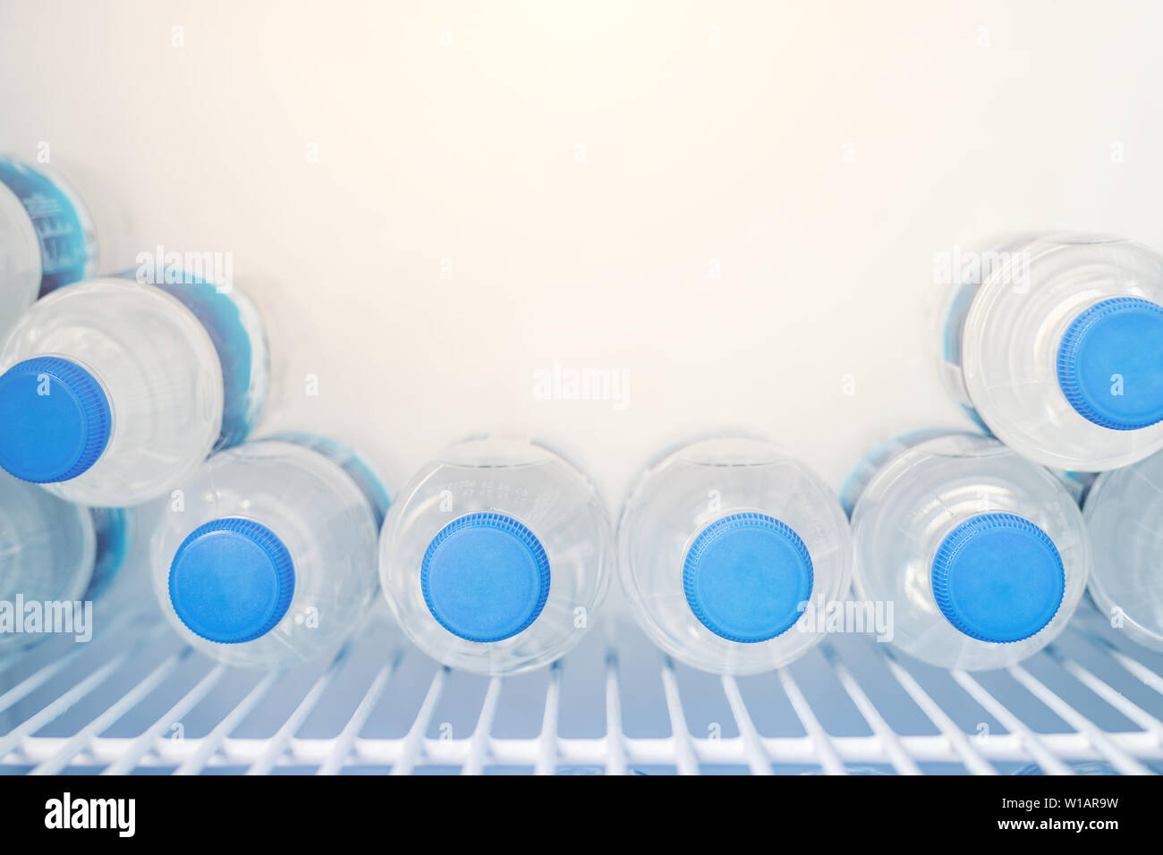 https://c8.alamy.com/comp/W1AR9W/rows-of-many-transparent-plastic-bottles-with-drinking-water-supply-in-white-refrigerator-mineral-water-stack-storage-in-fridge-to-drink-on-hot-W1AR9W.jpg