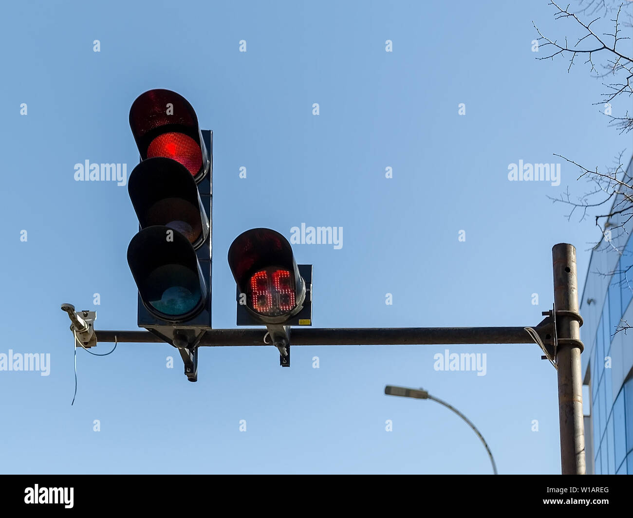 Red car traffic light and countdown timer installed on a pole above a