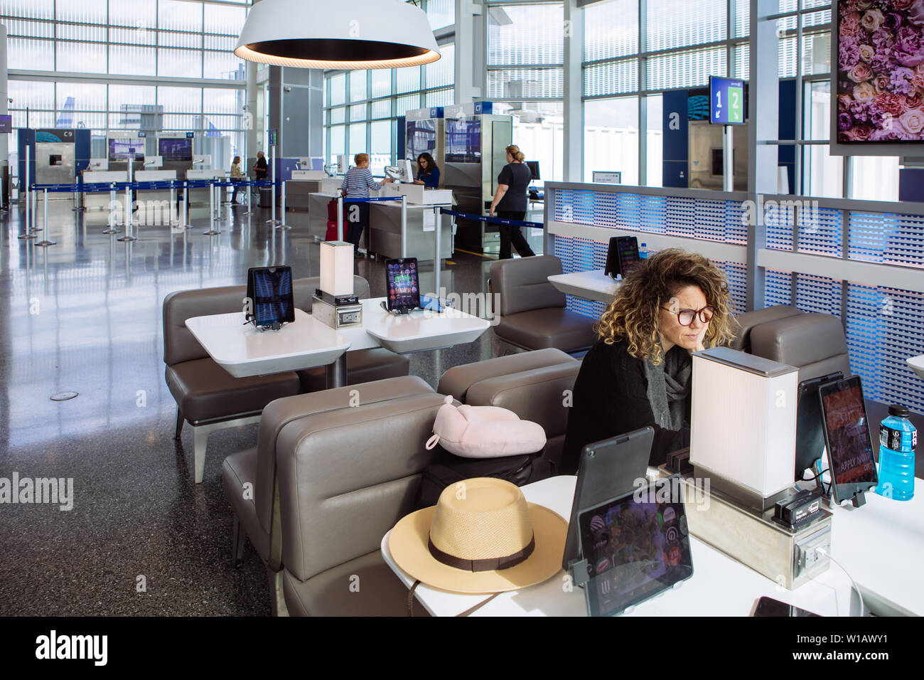 A tourist woman sitting in a table ordering food through an ipad tablet