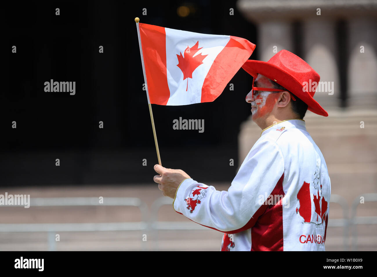 A proud Canadian waves his flag at a Canada Day event at Queen's Park in Toronto, Ontario. Stock Photo
