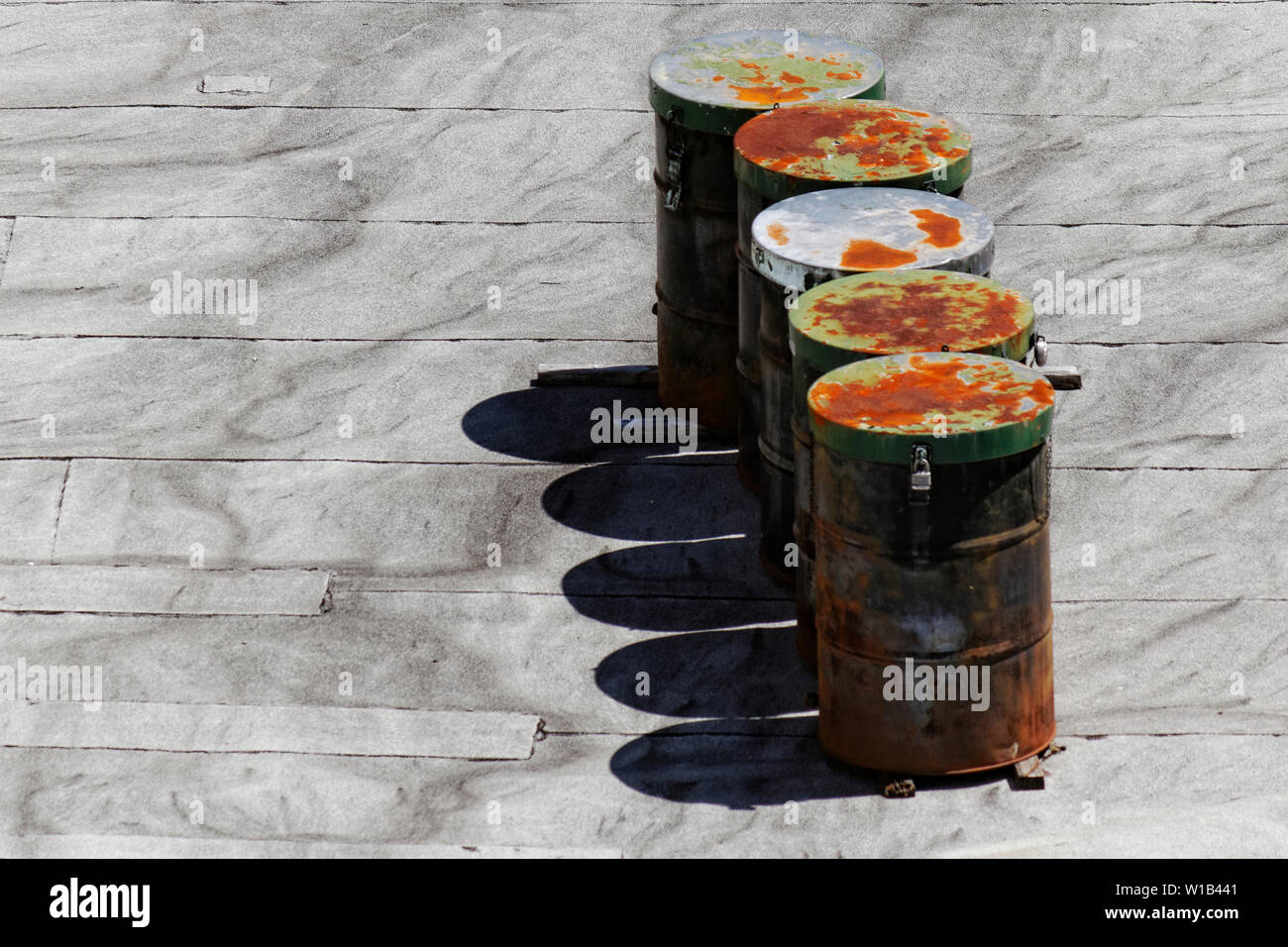 Five rusty industrial steel drums cast their shadows on an urban rooftop Stock Photo Alamy