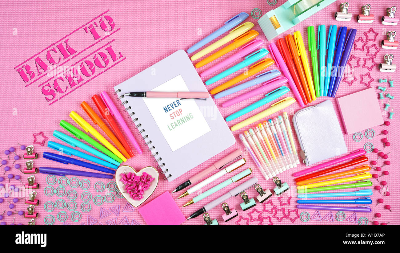 Back to school or workspace colorful stationery overhead on pink ...