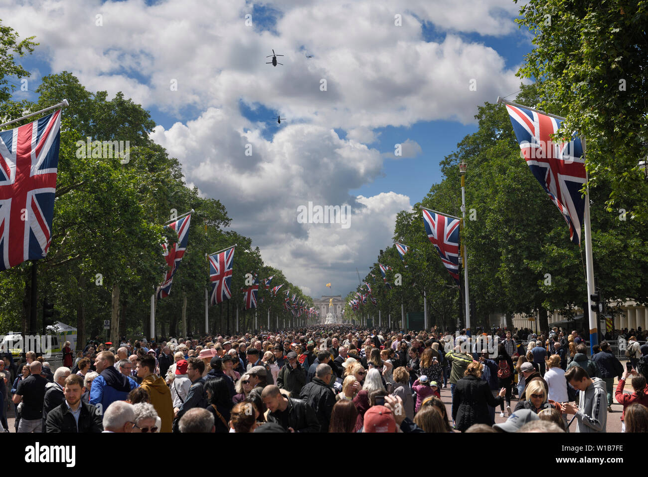 Helicopter flypast at The Mall with Union Jack flags and crowds for Trooping the Colour 2019 London England at Buckingham Palace Stock Photo