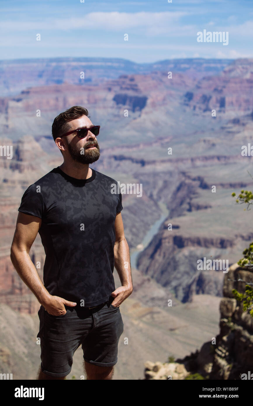 Fit man middle age caucasian tourist with sungalasses looking off the camera in South Rim, Grand Canyon National Park, Arizona, USA Stock Photo