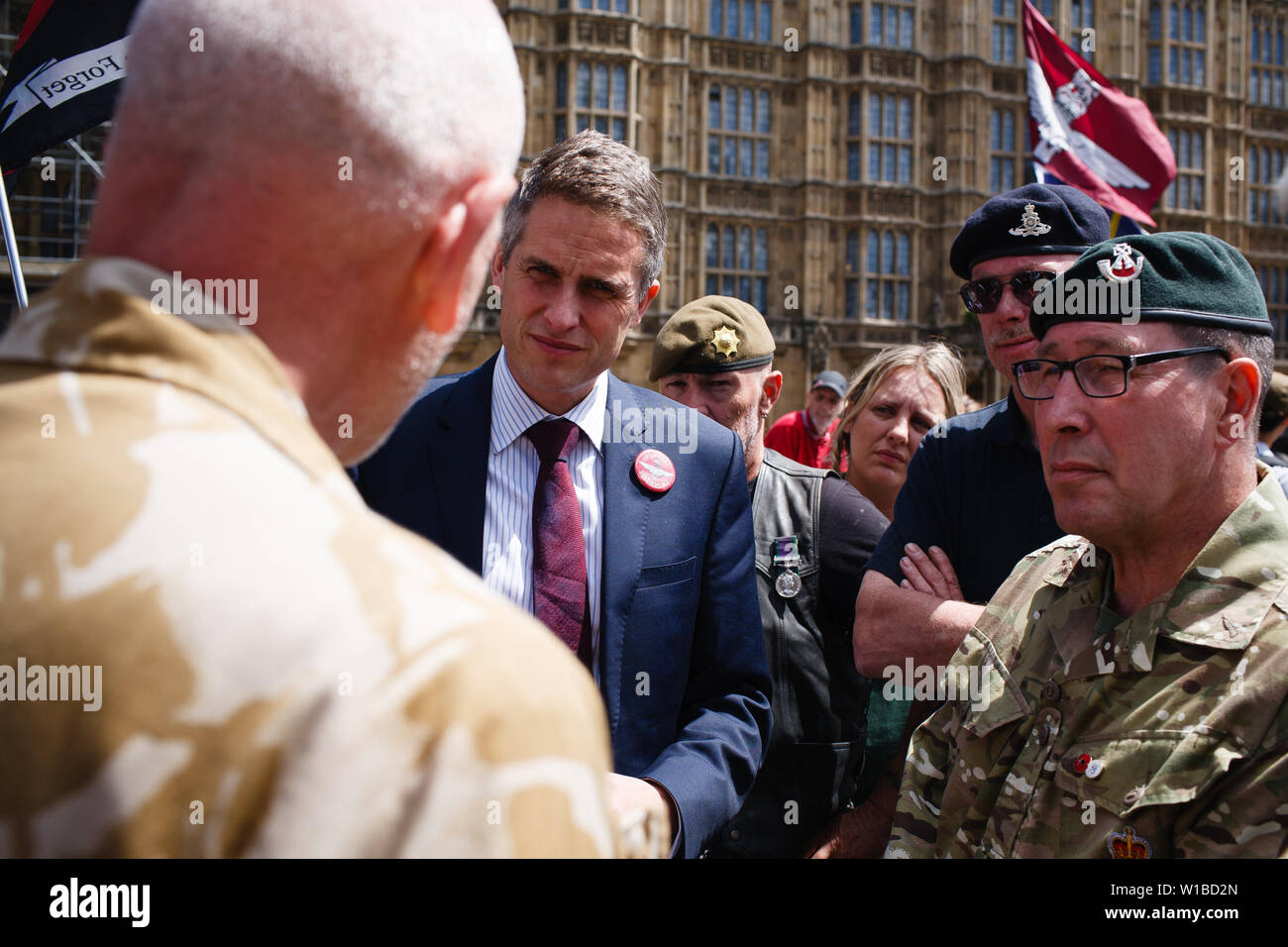 Britain's former Secretary of State for Defence Gavin Williamson speaks with veterans protesting the prosecution of former British soldiers for wartime killings at a demonstration outside the Houses of Parliament. The demonstration centred on the ongoing case of the as-yet-unnamed 'Soldier F', charged with two counts of murder for killings on Bloody Sunday in Londonderry, Northern Ireland, in 1972. Stock Photo