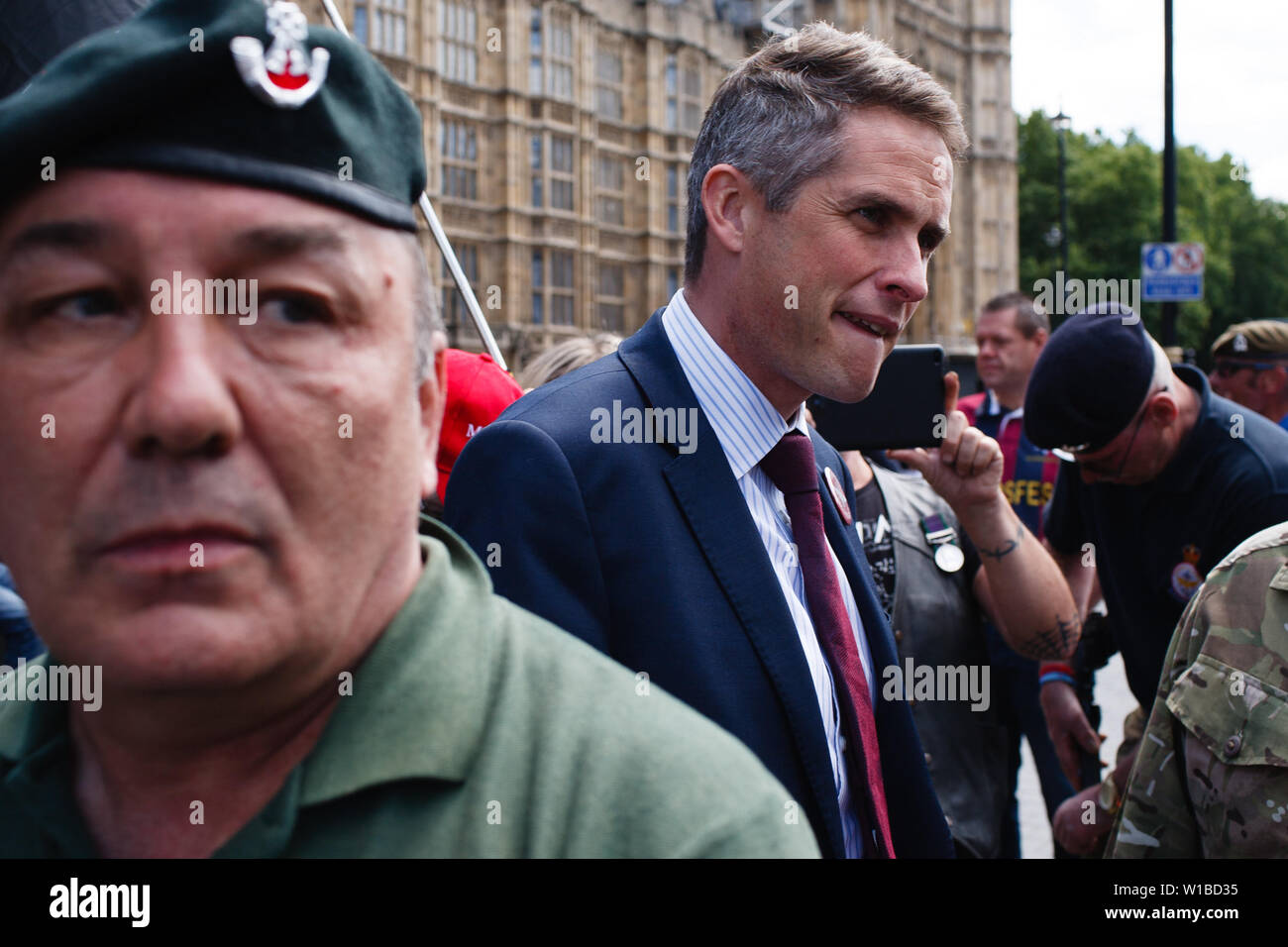 Britain's former Secretary of State for Defence Gavin Williamson speaks with veterans protesting the prosecution of former British soldiers for wartime killings at a demonstration outside the Houses of Parliament. The demonstration centred on the ongoing case of the as-yet-unnamed 'Soldier F', charged with two counts of murder for killings on Bloody Sunday in Londonderry, Northern Ireland, in 1972. Stock Photo