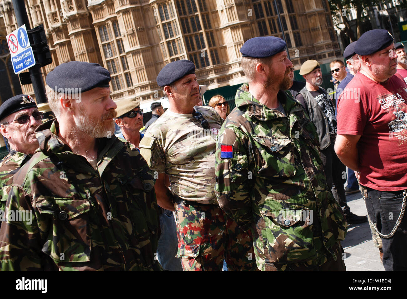 Veterans protesting the prosecution of former British soldiers for wartime killings stand in formation at a demonstration outside the Houses of Parliament. The demonstration centred on the ongoing case of the as-yet-unnamed 'Soldier F', charged with two counts of murder for killings on Bloody Sunday in Londonderry, Northern Ireland, in 1972. Stock Photo