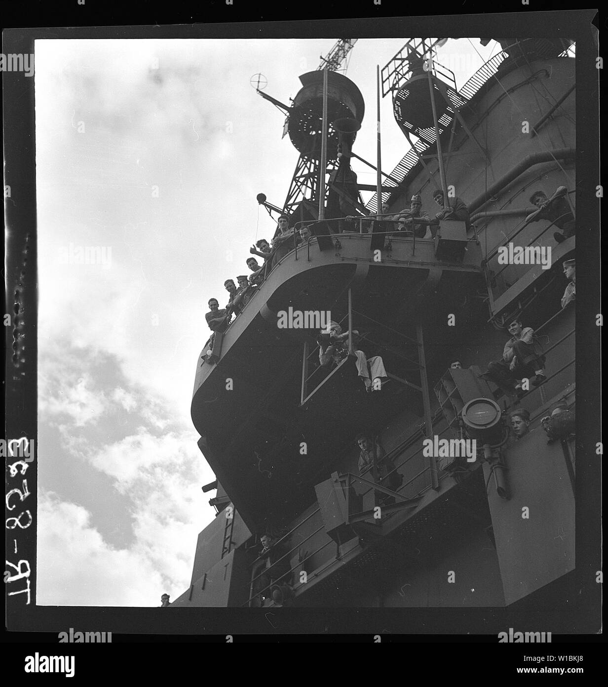 Cdr. E.J. Steichen on framework below flight deck taking combat photos