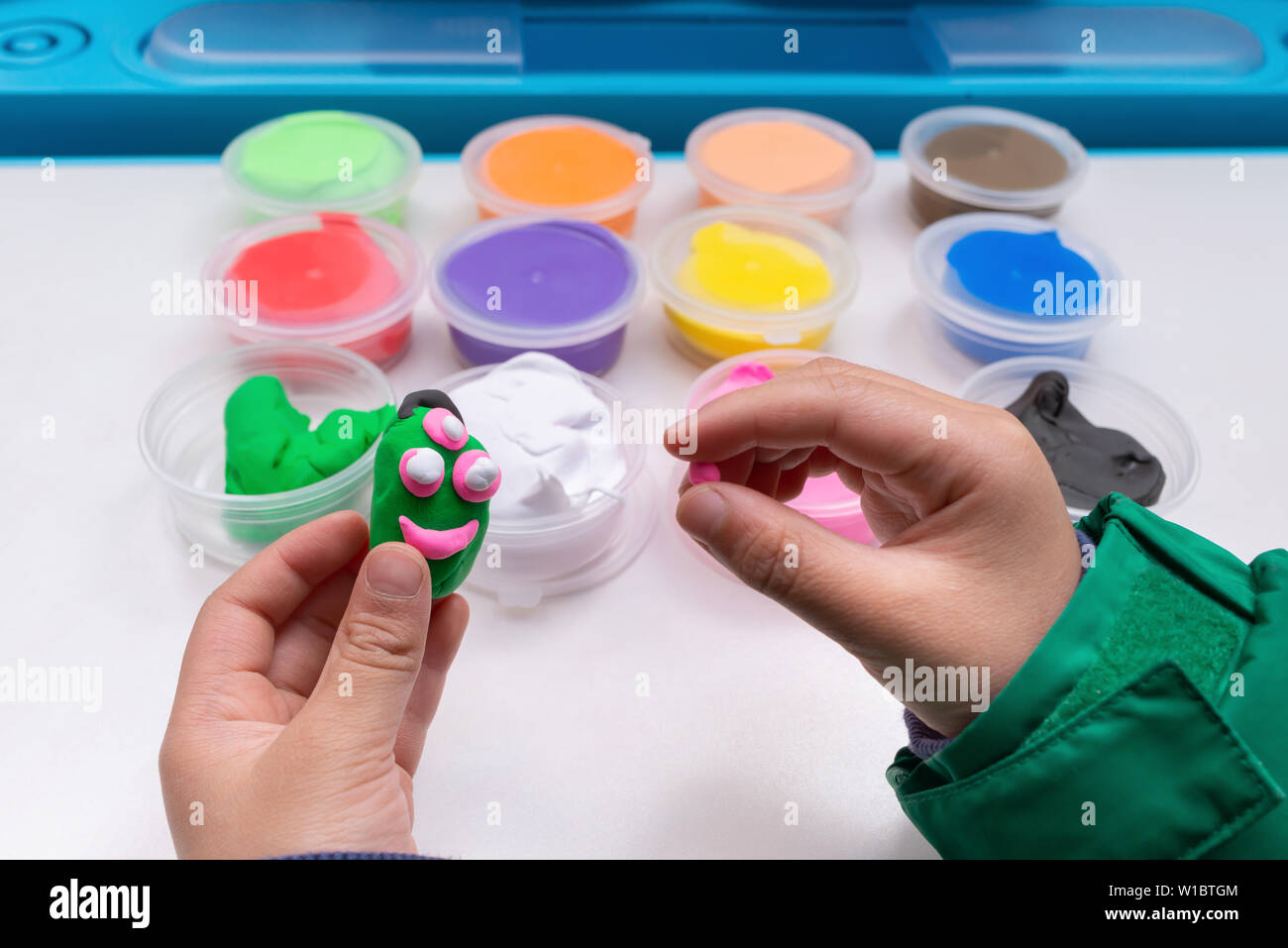 kid playing plasticine and modeling something cute Stock Photo