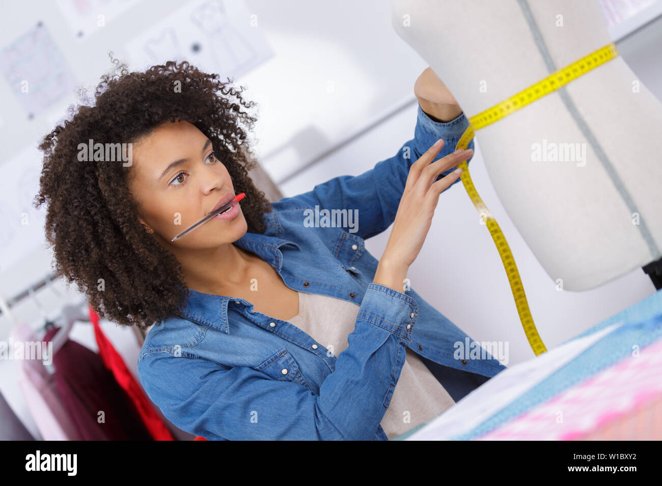 young tailor measuring the mannequins waist Stock Photo Alamy