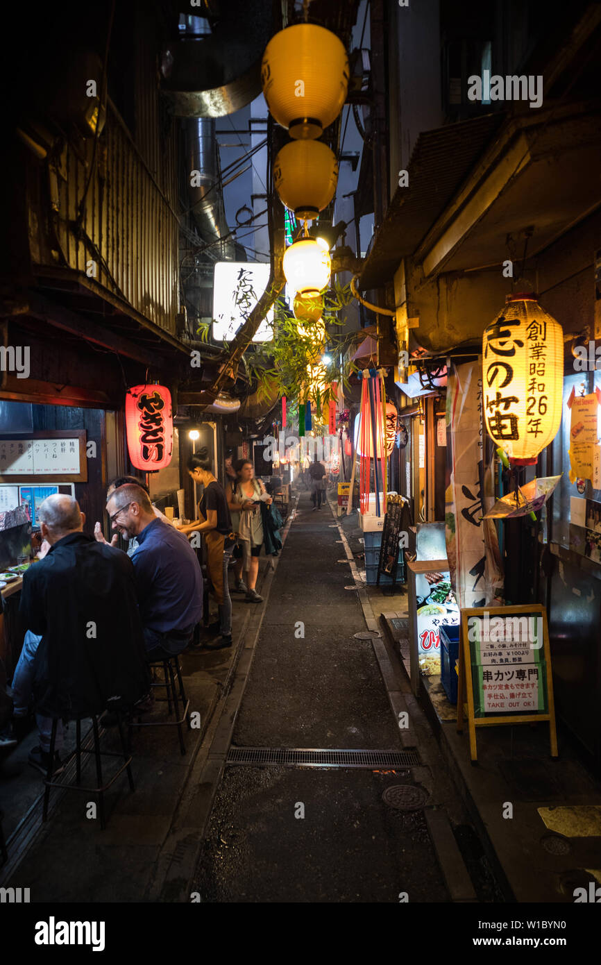View of the alley at Omoide Yokocho at night. Traditional Japanese building. Portrait Orientation. Stock Photo