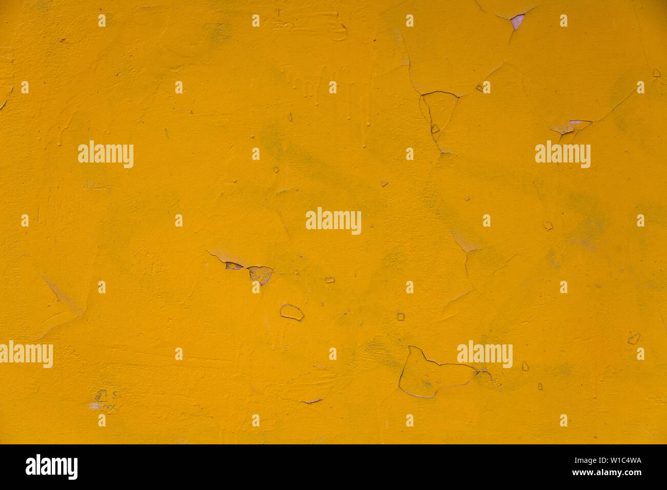 Background from a rough concrete wall with old yellow paint that falls