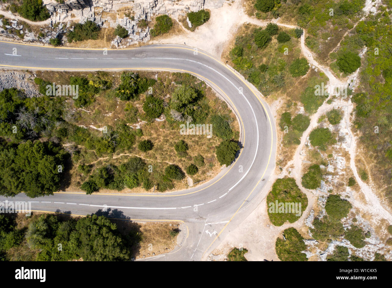 Mountain road surrounded by lush green forest, Aerial image Stock Photo ...