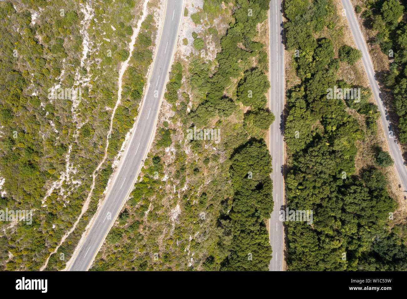 Mountain road surrounded by lush green forest, Aerial image Stock Photo ...