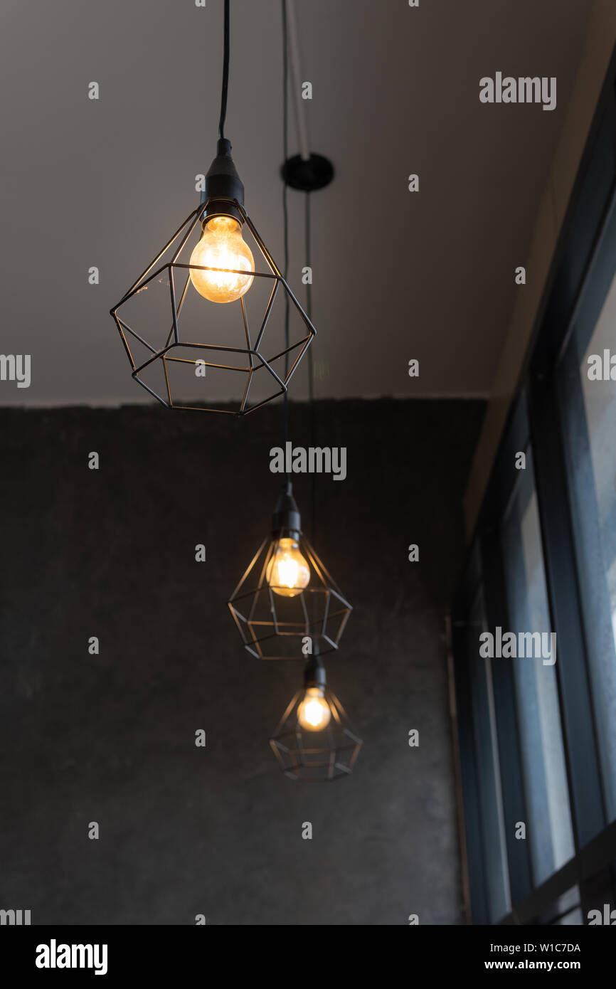 Light Bulb In Black Steel Cage Hang On Ceiling In Coffee Shop