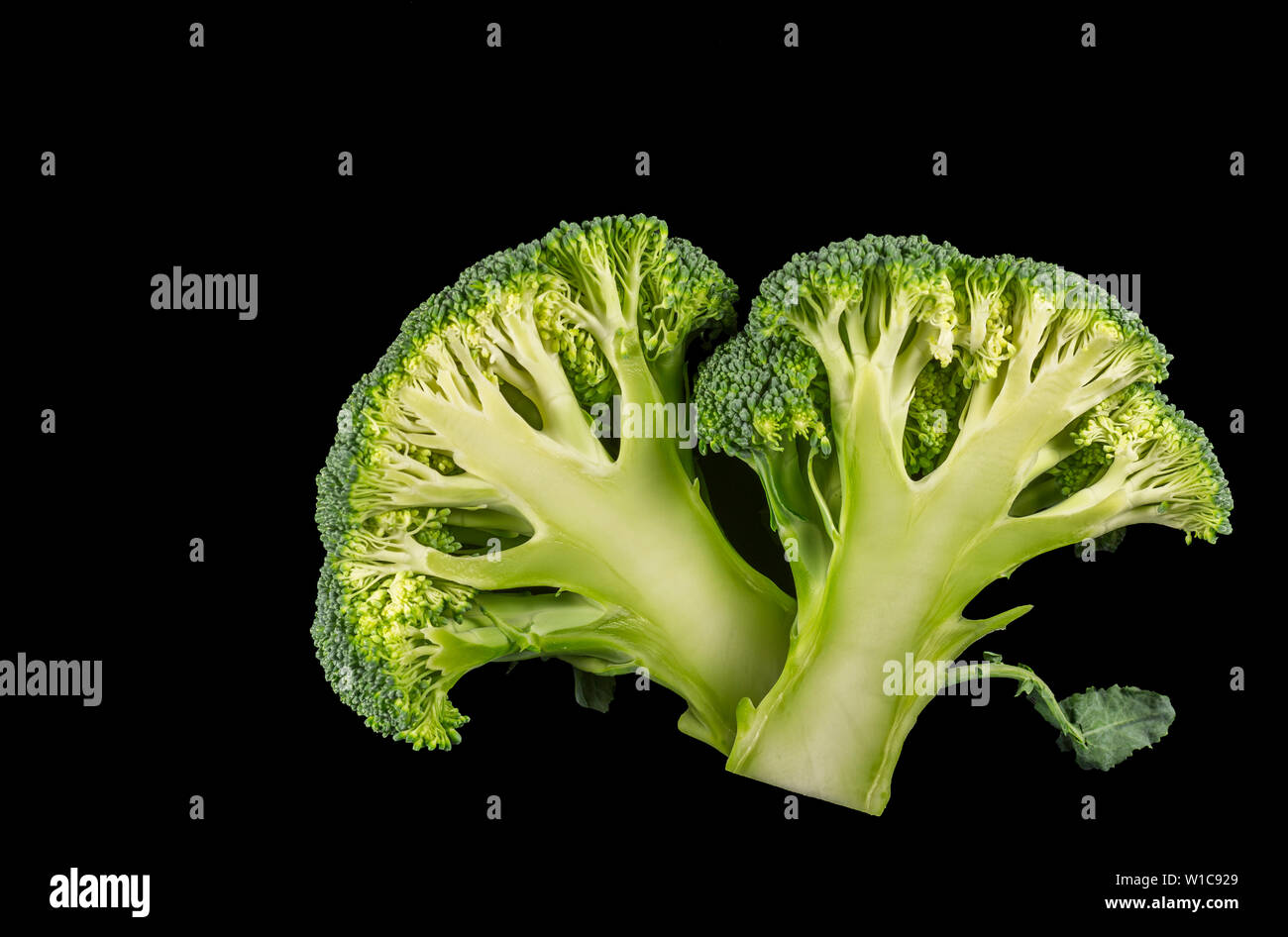 Broccoli florets cut in half on a black background Stock Photo