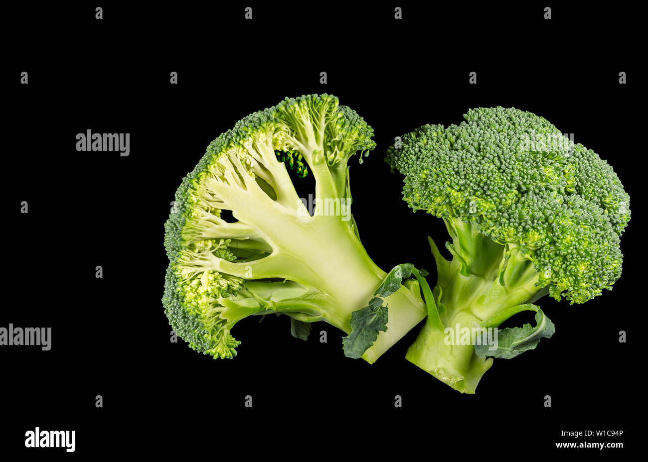 Broccoli florets cut in half on a black background Stock Photo