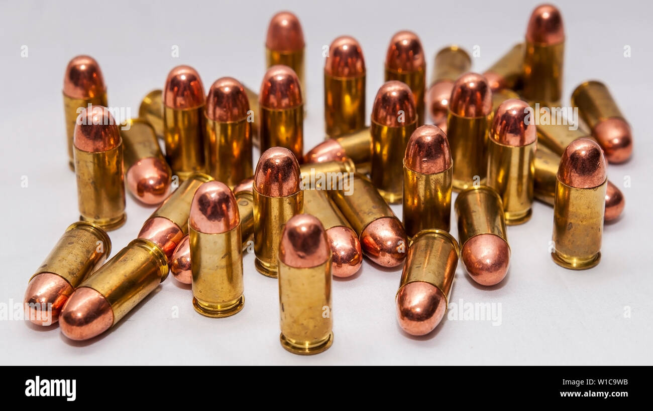 A group of 45 caliber full metal jacket bullets on a white background