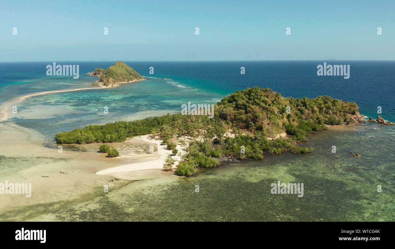 aerial view tropical island in blue lagoon, coral reef and sandy beach ...