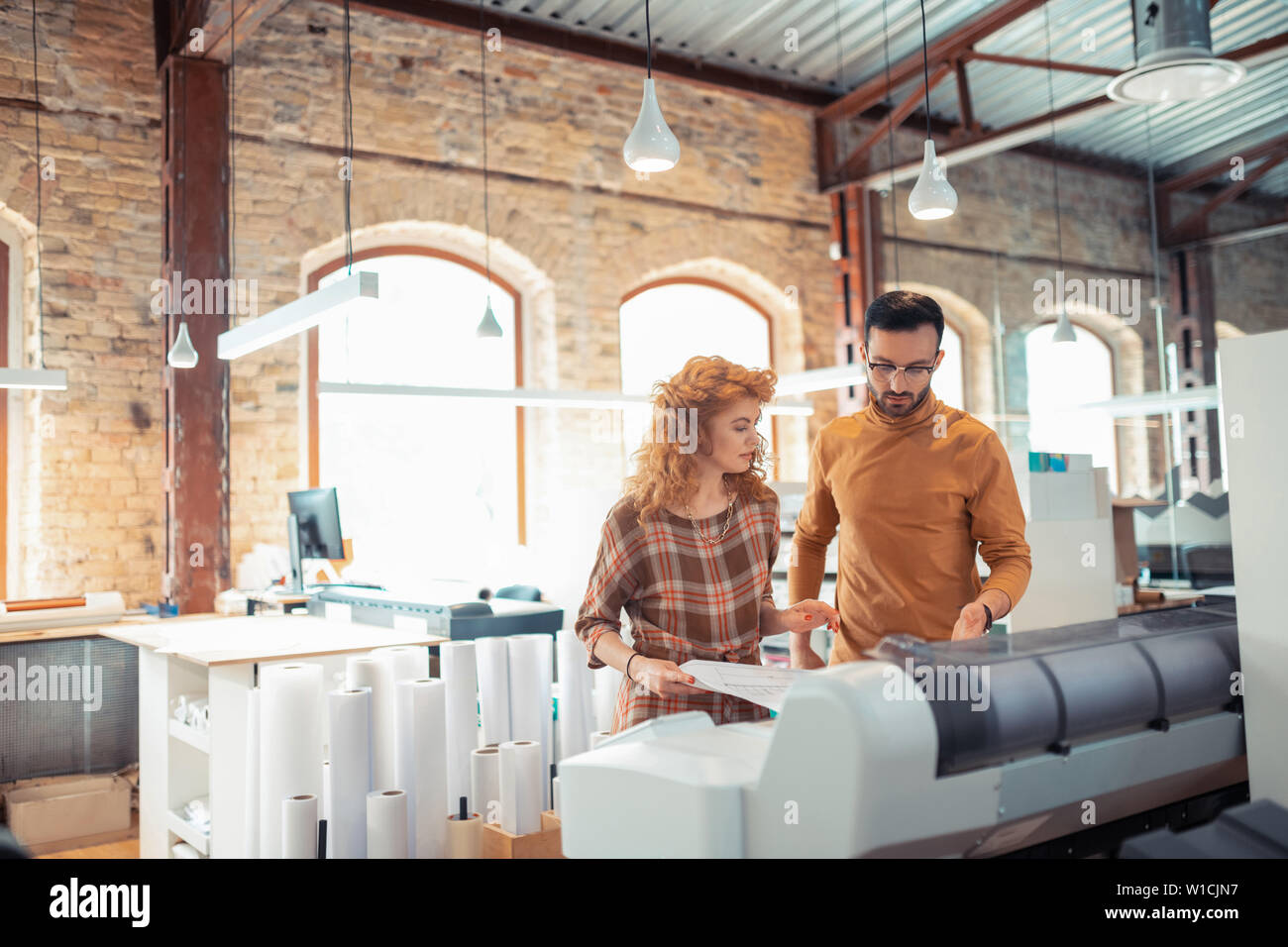 Interior designers working. Two hard-working interior designers working in spacious office together Stock Photo