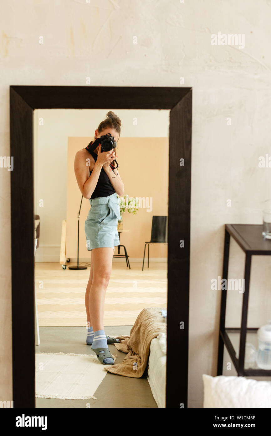 Young female taking picture in mirror Stock Photo