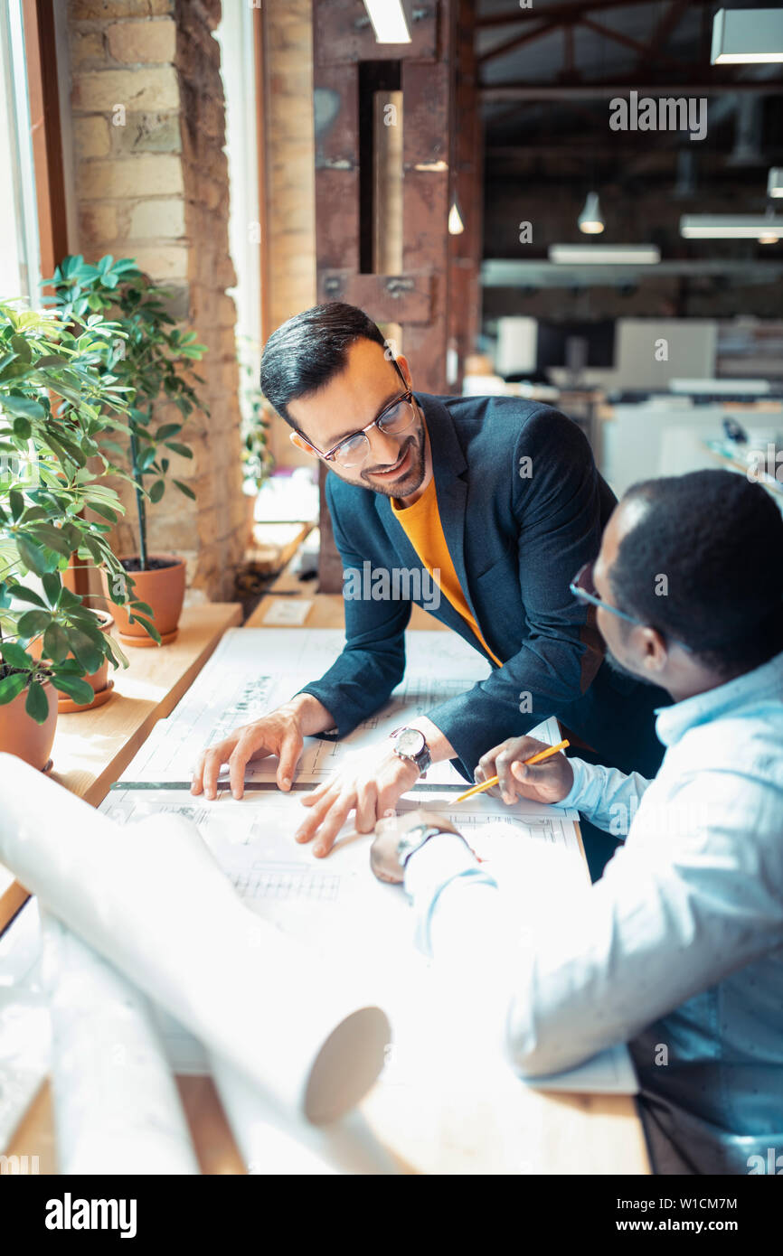 Cooperating on project. Two interior designers feeling cheerful while cooperating on project together Stock Photo