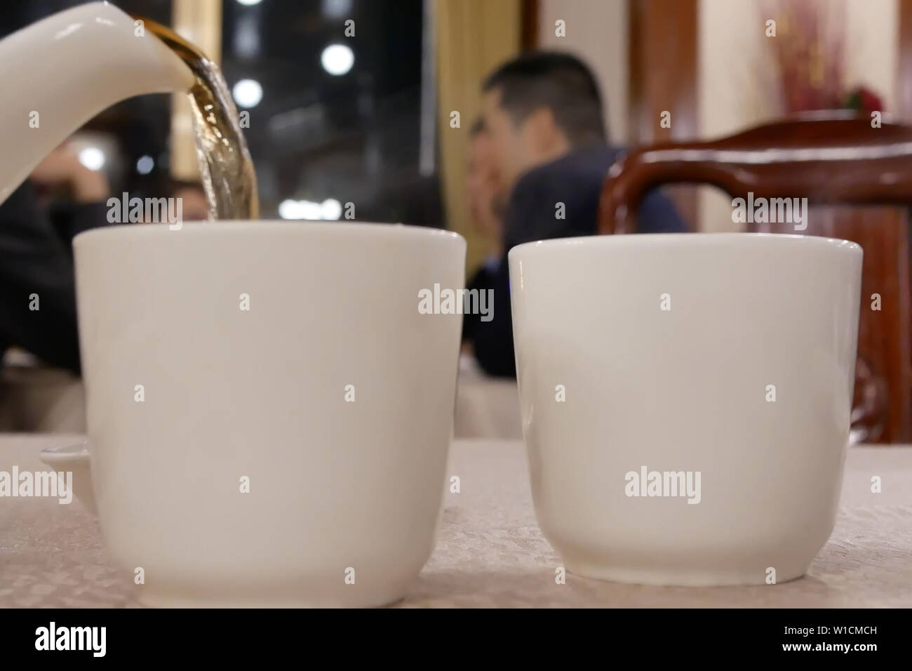 Motion of people pouring hot tea inside Chinese restaurant Stock Photo