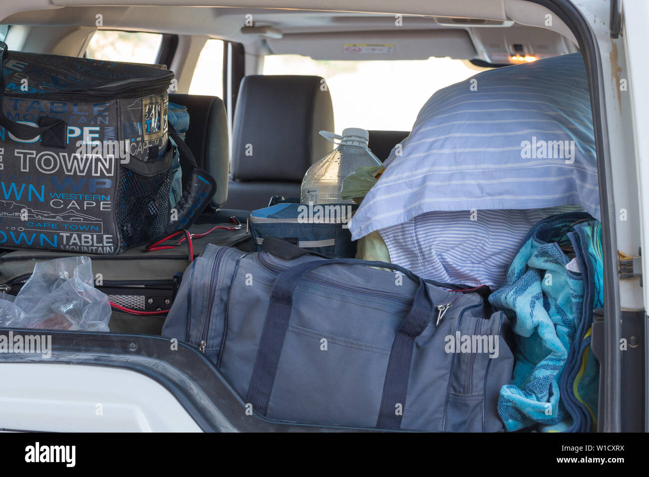 open car boot filled with luggage for a long car trip or journey overland holiday or vacation Stock Photo