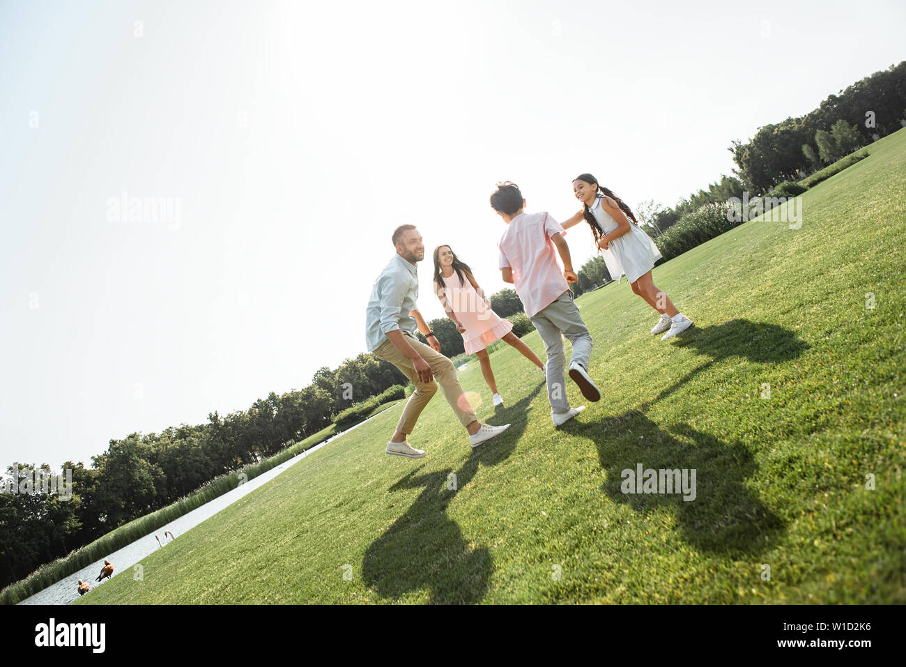 Carefree time. Happy young family playing and smiling while spending free time with family outdoors in park. Family concept Stock Photo