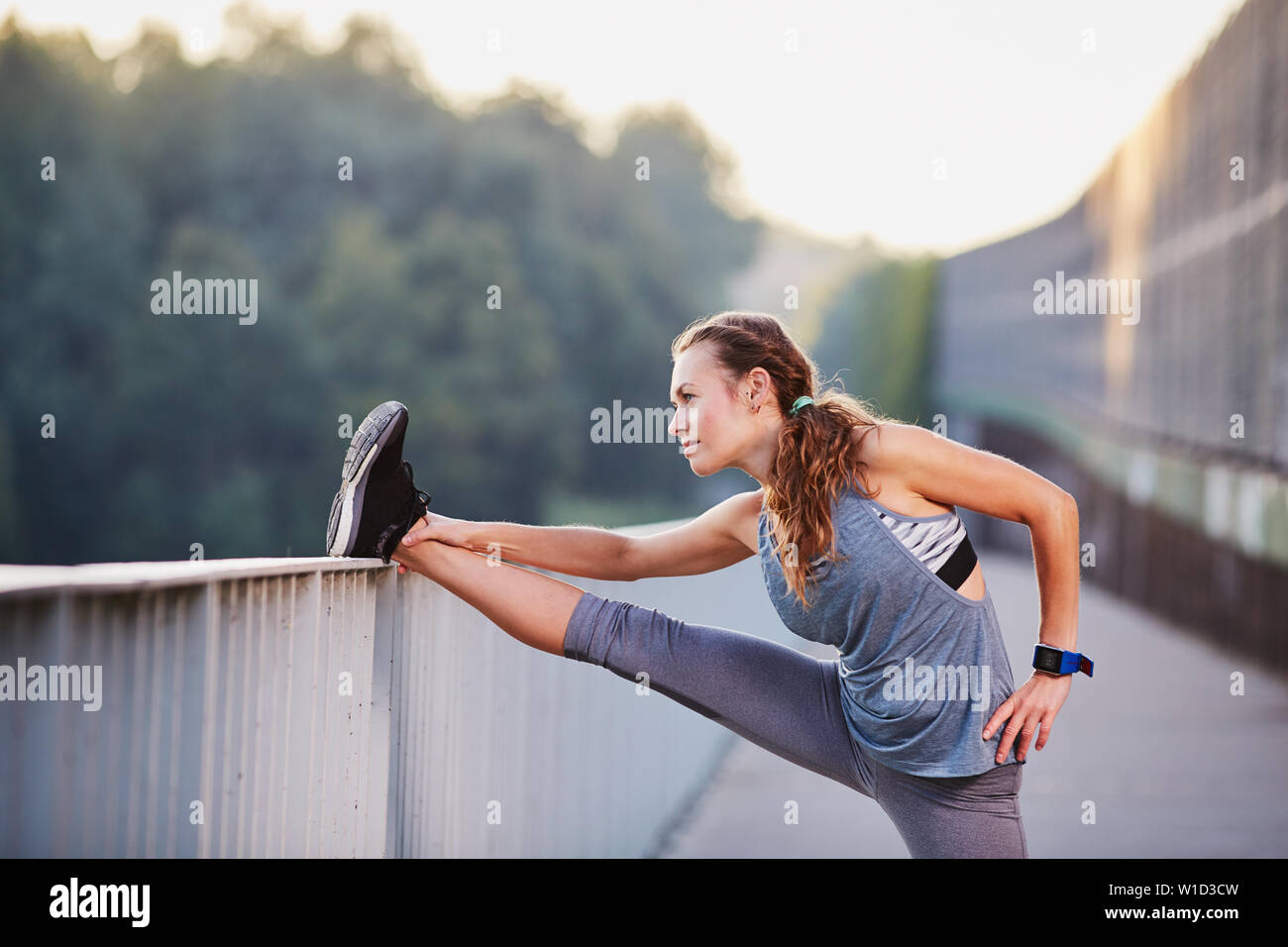 Fit woman stretching legs after running Stock Photo - Alamy