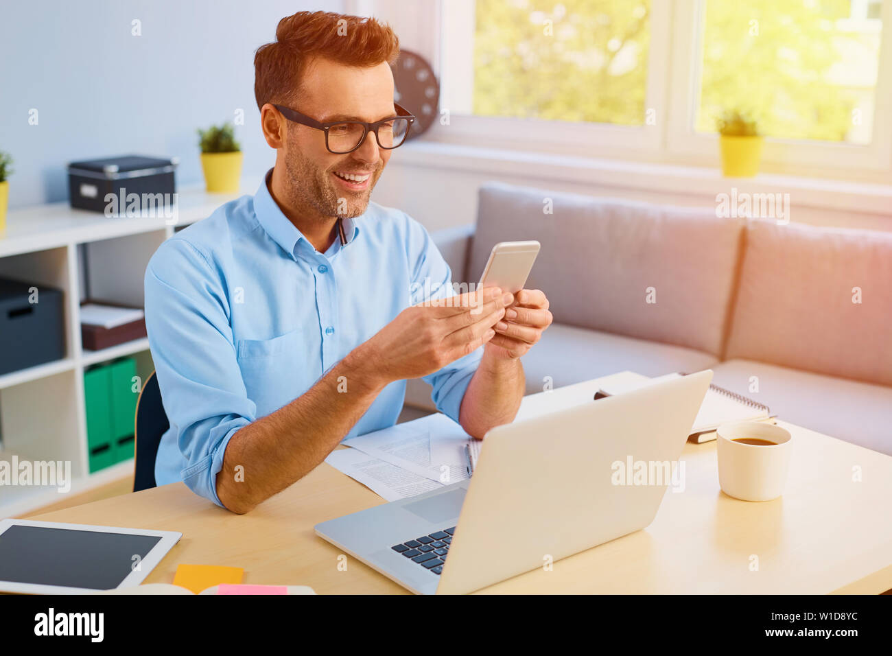 Handsome man paying bills with his phone Stock Photo