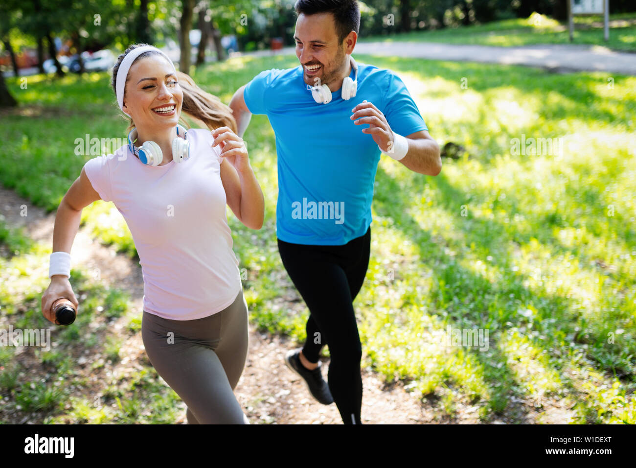 Happy couple jogging and running outdoors in nature Stock Photo - Alamy