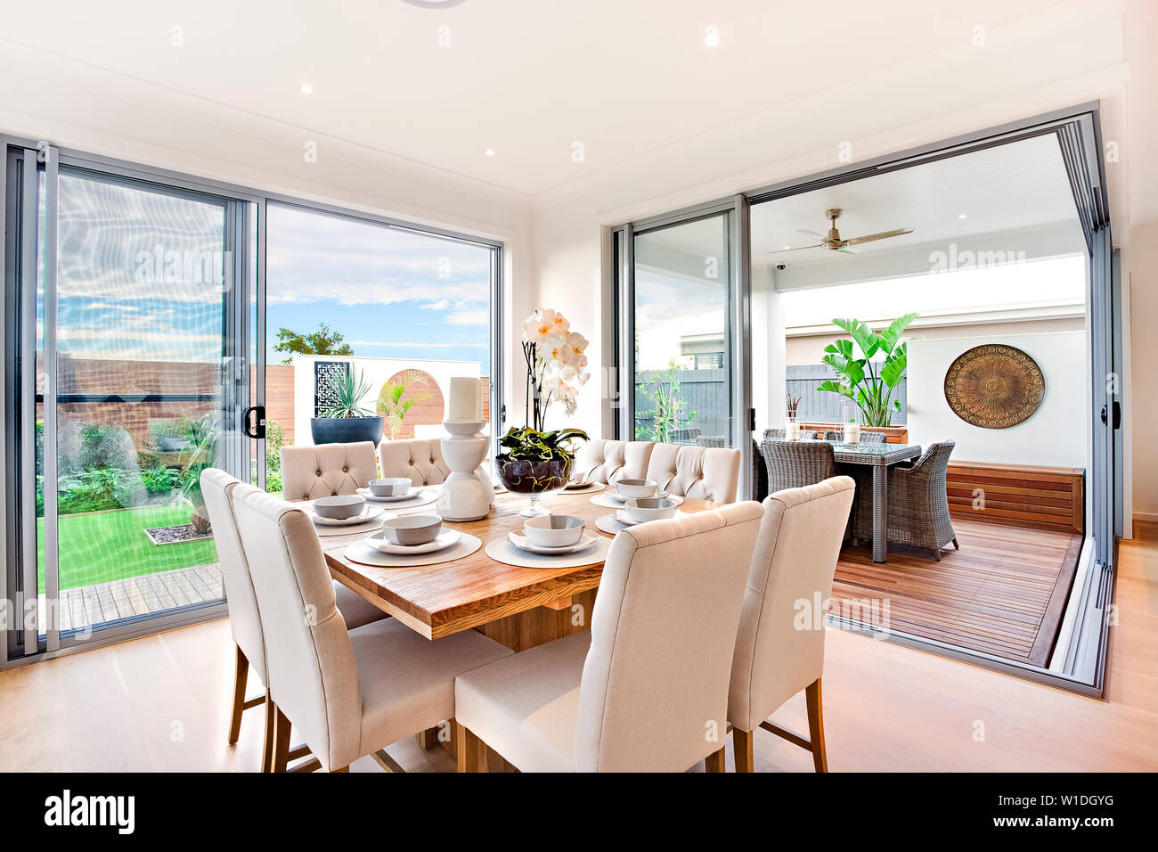 Luxurious dining table overlooking a beautiful view of the sky, divided from the snack table in the gallery with glass doors. Stock Photo