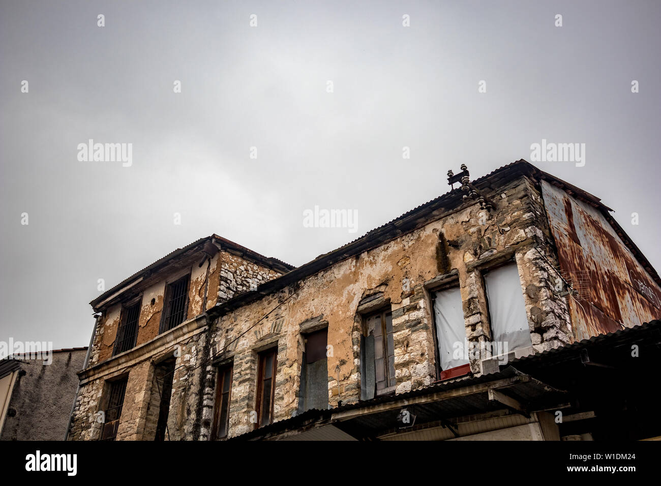 Old Greek industrial building under construction with bricks visible, Ioannina downtown, Greece. Moody foggy spring morning, no people Stock Photo