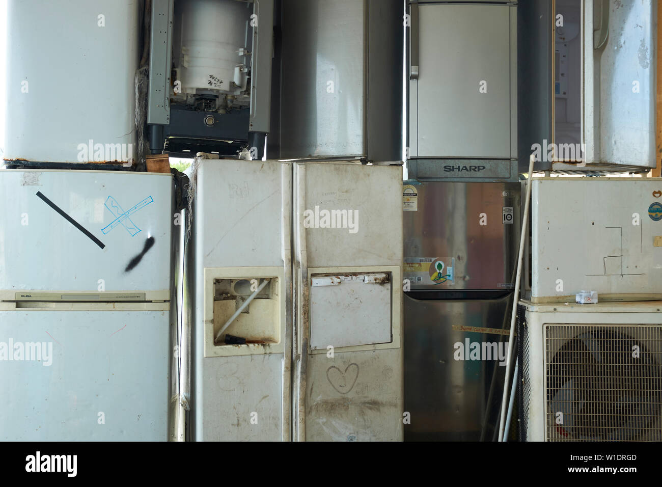 Old refridgerators and appliances ready for recycling outside a shop in Miri, Borneo, Malaysia. Stock Photo