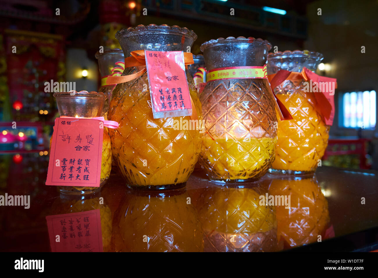 Glass pineapple candle jars lined up at Tua Pek Kong Chinese temple in