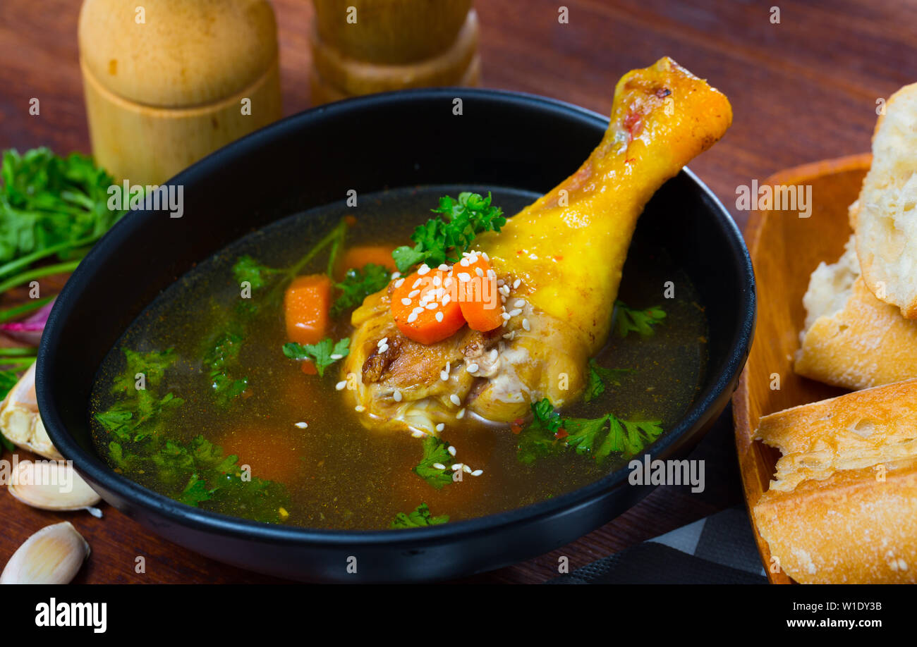 Homemade chicken bouillon with chicken leg, carrot and parsley Stock